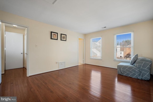 unfurnished room with wood-type flooring, visible vents, and baseboards