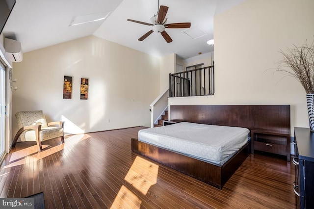 bedroom featuring attic access, a ceiling fan, wood finished floors, vaulted ceiling, and a wall mounted AC