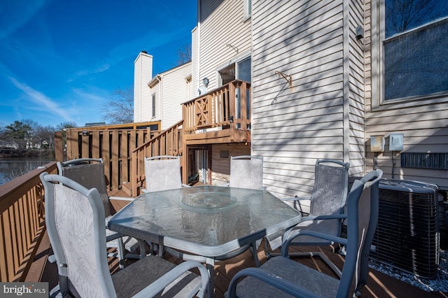 wooden deck with outdoor dining area and cooling unit