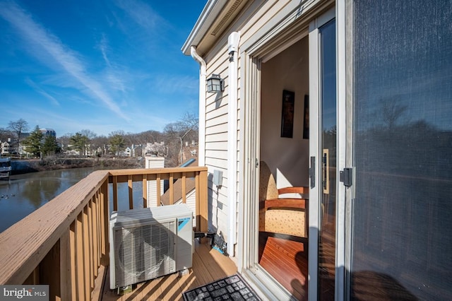 wooden deck featuring ac unit and a water view