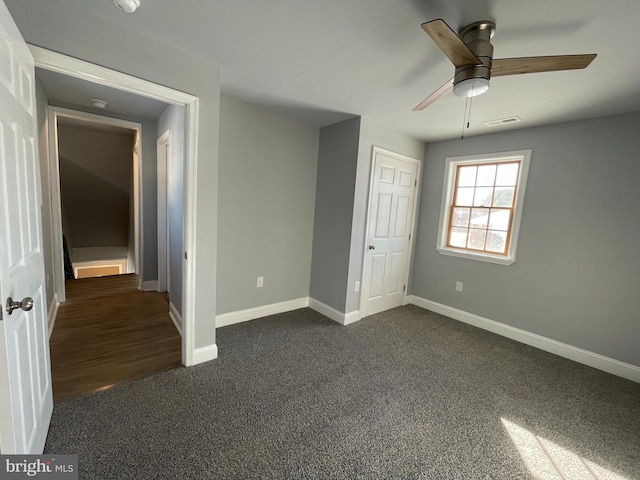 unfurnished bedroom featuring dark colored carpet and ceiling fan