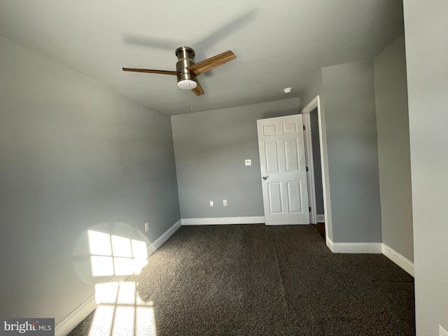 unfurnished room with ceiling fan and dark carpet