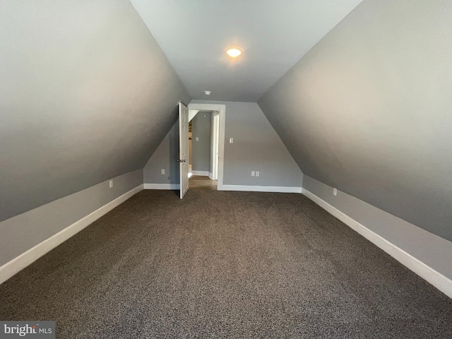 bonus room with carpet flooring and vaulted ceiling