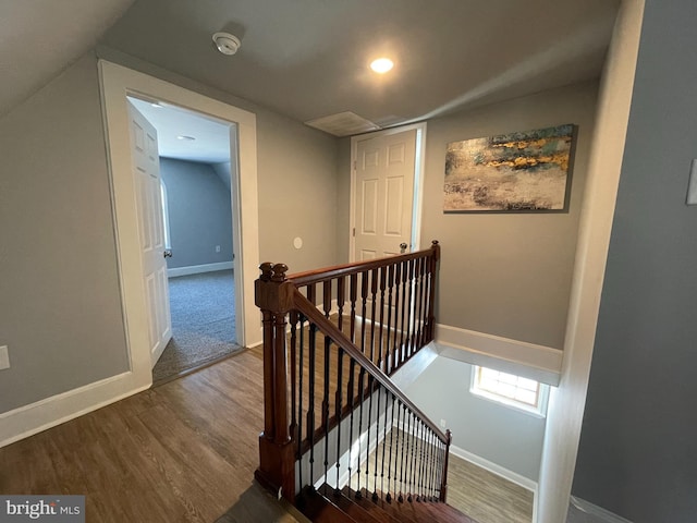 stairs featuring hardwood / wood-style floors and lofted ceiling