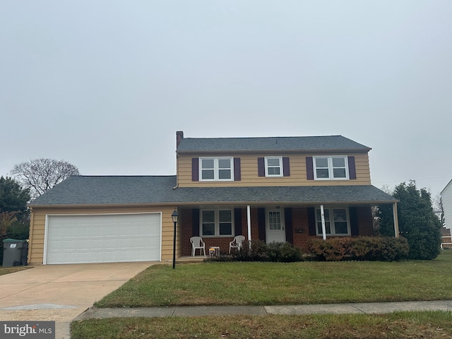 view of front of home with covered porch, a front yard, and a garage