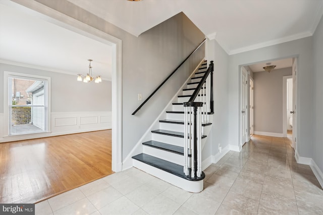 staircase with tile patterned flooring, an inviting chandelier, and crown molding