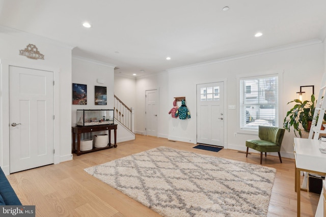 foyer with light hardwood / wood-style flooring and crown molding