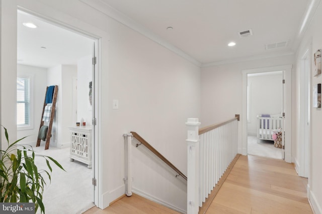 corridor featuring light hardwood / wood-style flooring and ornamental molding