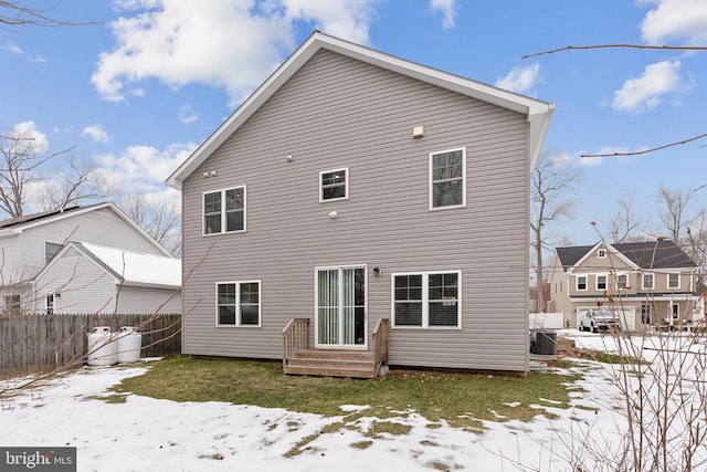 snow covered house featuring cooling unit