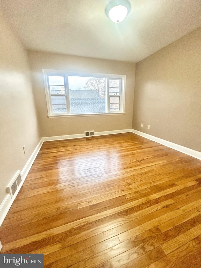 unfurnished room with hardwood / wood-style flooring