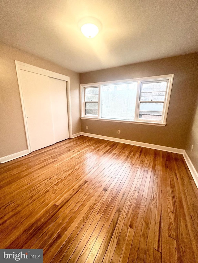 unfurnished bedroom with a closet and light hardwood / wood-style flooring