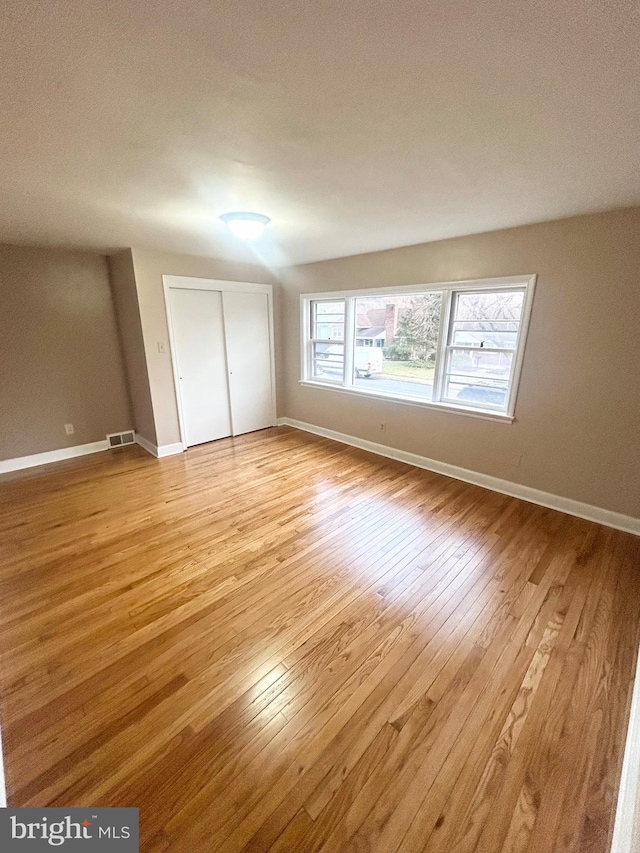 unfurnished bedroom featuring light hardwood / wood-style floors and a closet