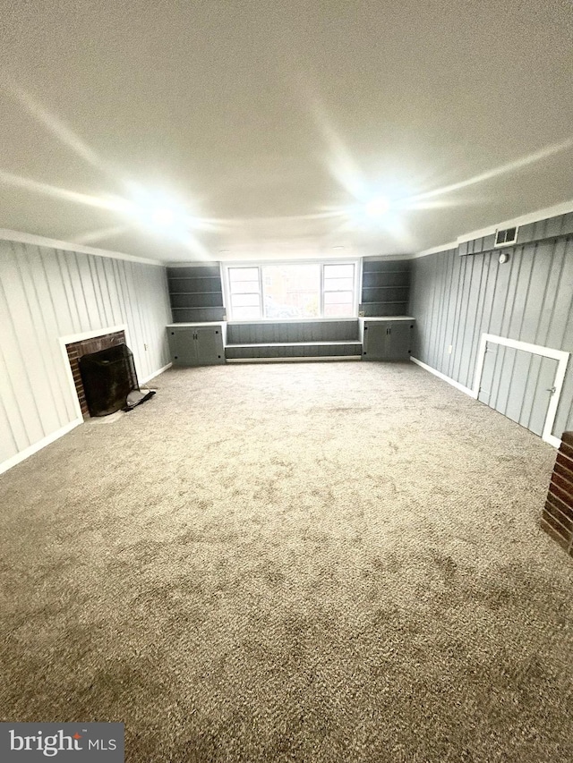 unfurnished living room with a textured ceiling, carpet floors, and a fireplace