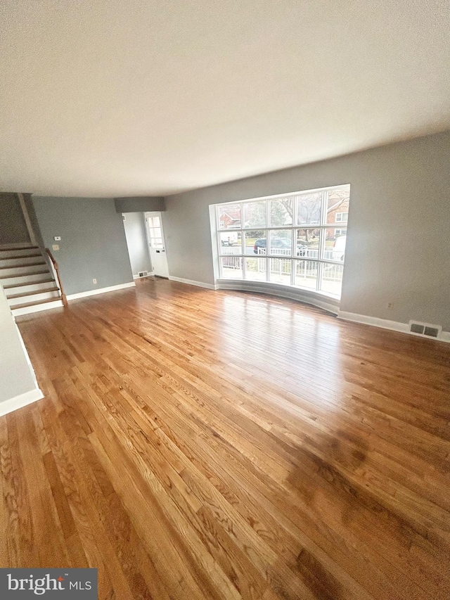 unfurnished living room with a wealth of natural light and hardwood / wood-style floors