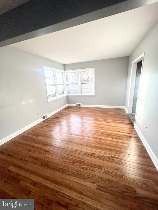 empty room with dark hardwood / wood-style flooring