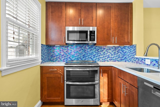 kitchen with decorative backsplash, sink, and appliances with stainless steel finishes