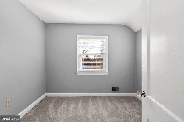 unfurnished room featuring carpet flooring and lofted ceiling