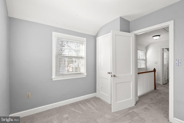 interior space featuring light colored carpet, a wealth of natural light, and lofted ceiling