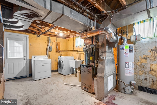 basement featuring sink, washer and dryer, and water heater