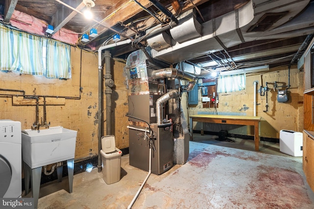 basement with heating unit, electric panel, and washer / clothes dryer