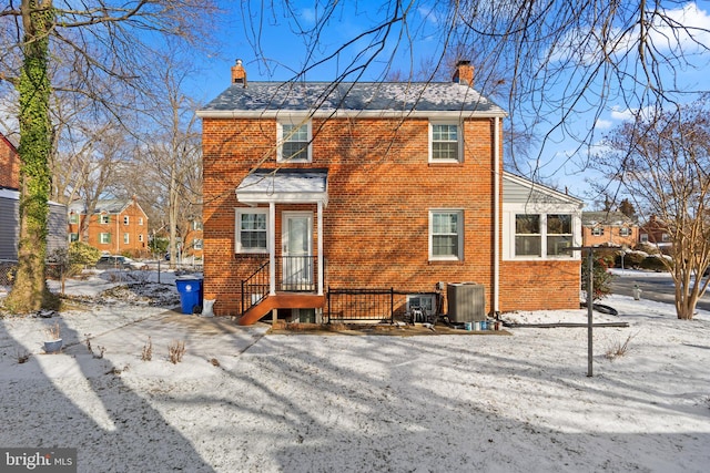 snow covered back of property with central air condition unit