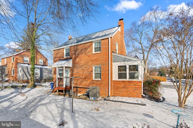 snow covered property featuring central AC unit