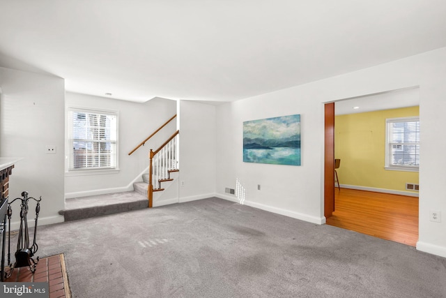 unfurnished living room with a wealth of natural light and carpet flooring