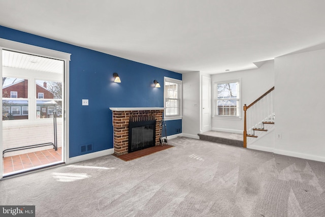 unfurnished living room featuring light colored carpet and a fireplace