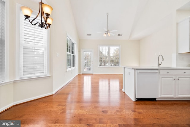 kitchen featuring lofted ceiling, sink, white cabinetry, white dishwasher, and ceiling fan with notable chandelier