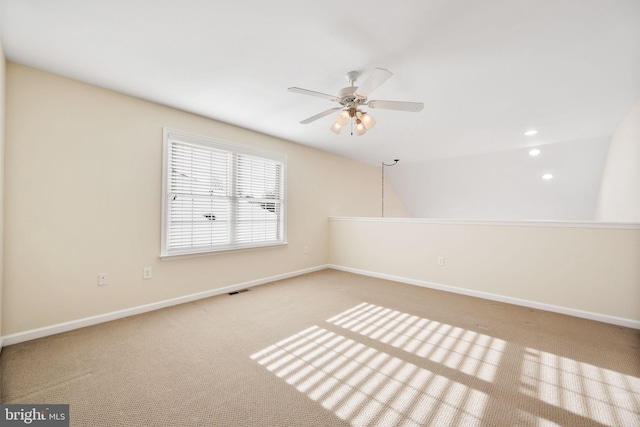 empty room with ceiling fan, lofted ceiling, and carpet