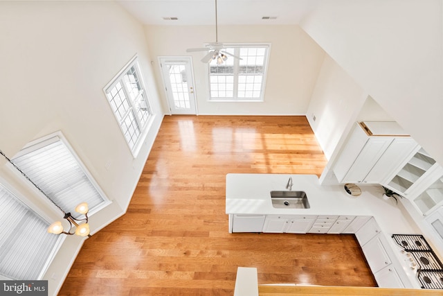 entrance foyer with sink, light hardwood / wood-style flooring, ceiling fan, and a high ceiling