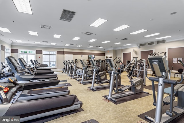 gym with light carpet and ornamental molding