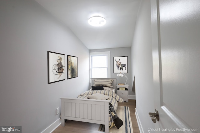 bedroom featuring light hardwood / wood-style floors and lofted ceiling