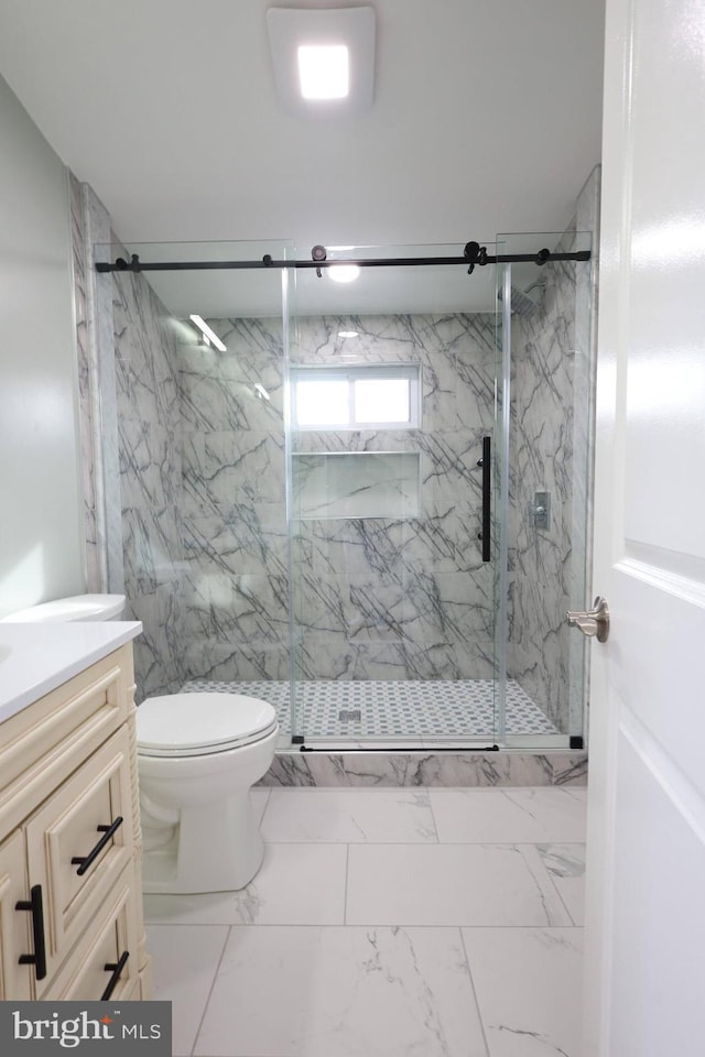 bathroom featuring vanity, toilet, and a shower with shower door