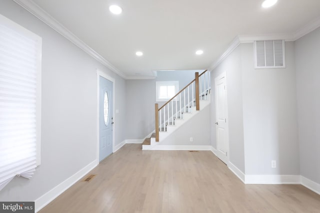 entryway with light hardwood / wood-style flooring and crown molding