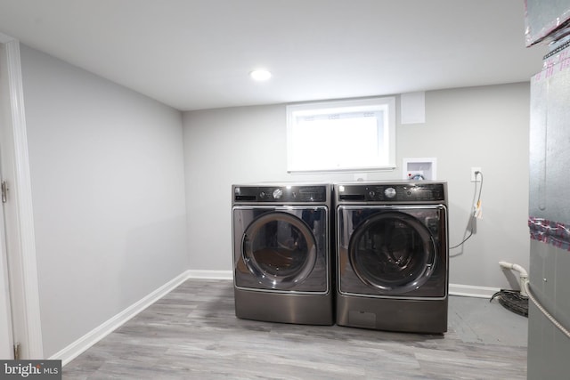 washroom featuring independent washer and dryer and light hardwood / wood-style flooring