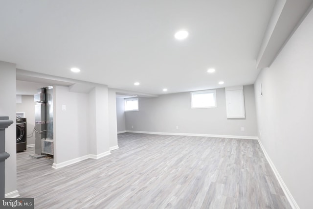 basement featuring washer / clothes dryer, a wealth of natural light, and light wood-type flooring