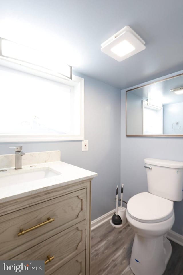 bathroom featuring hardwood / wood-style flooring, vanity, and toilet