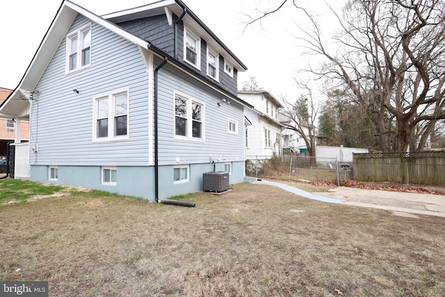 view of side of home with central air condition unit and a yard