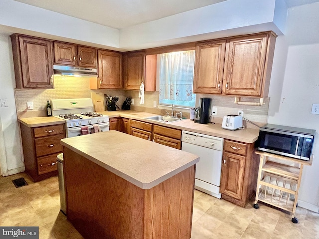 kitchen featuring tasteful backsplash, sink, and white appliances