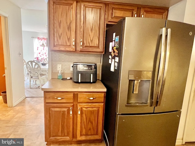 kitchen with decorative backsplash and stainless steel refrigerator with ice dispenser