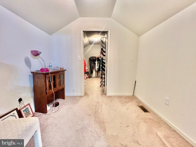 additional living space featuring light colored carpet and lofted ceiling