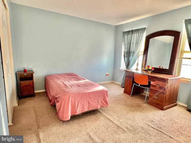 bedroom with light colored carpet and multiple windows