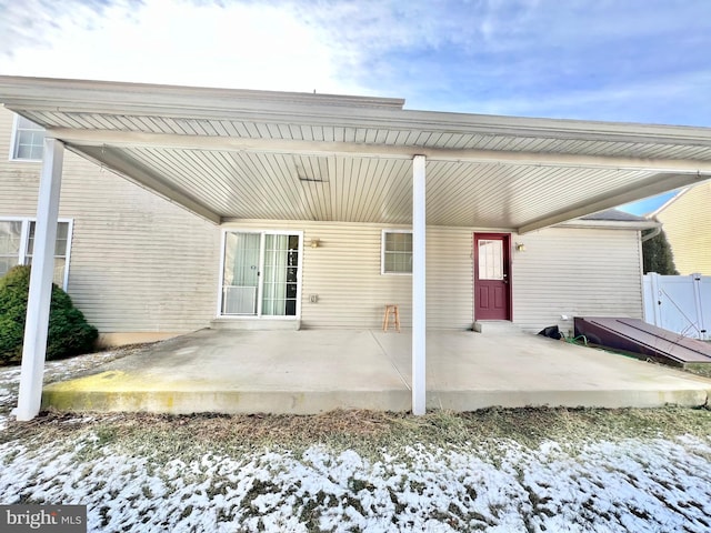 snow covered property with a patio