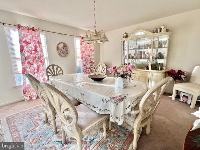 dining area with light colored carpet and an inviting chandelier