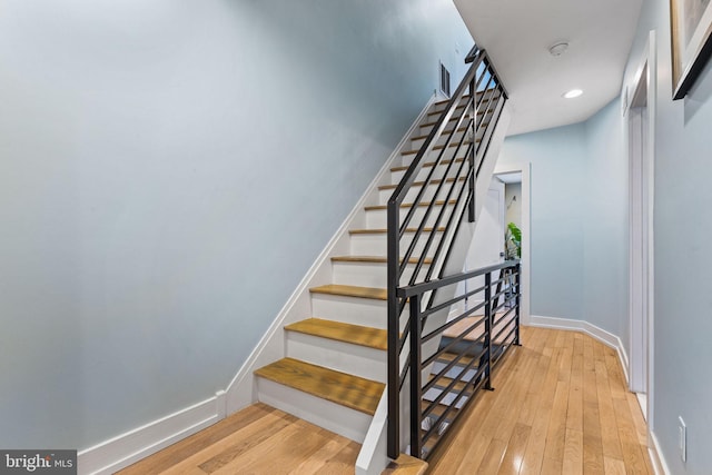 stairs featuring hardwood / wood-style flooring