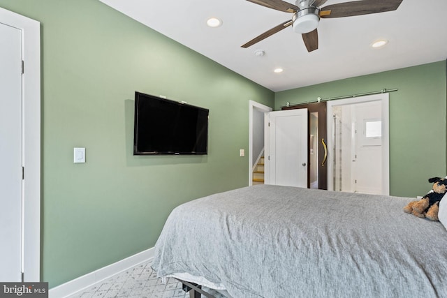 bedroom featuring a barn door and ceiling fan