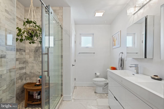 bathroom with vanity, a shower with door, and toilet