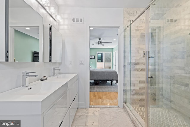 bathroom featuring a shower with door, vanity, and ceiling fan