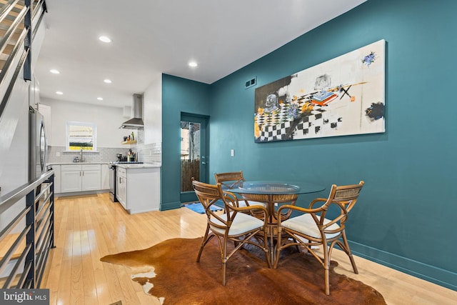 dining space with sink and light hardwood / wood-style flooring